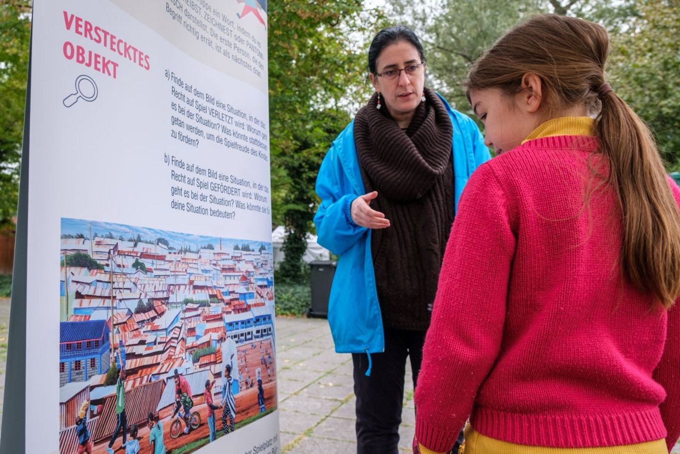 Frau und Kind betrachten das Wimmelbild in der Wanderausstellung. © Francois Botha